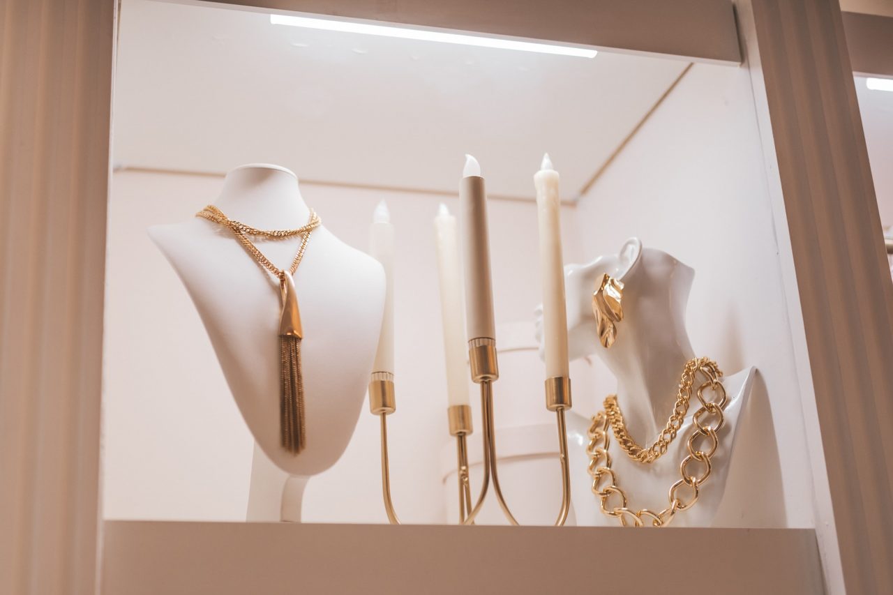 luxury gold jewelry on set holders and in jewelry box on light dressing table and wardrobe shelves 2